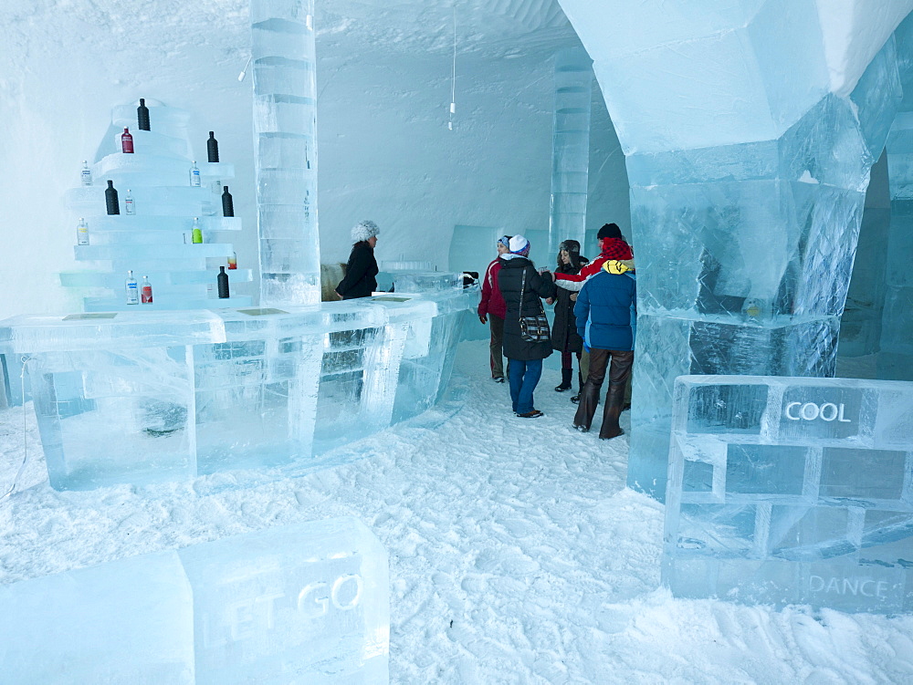 Visitors standing in the Absolut ice bar in the ice hotel in Jukkasjaervi, Kiruna, Lappland, northern Sweden, Sweden, Europe