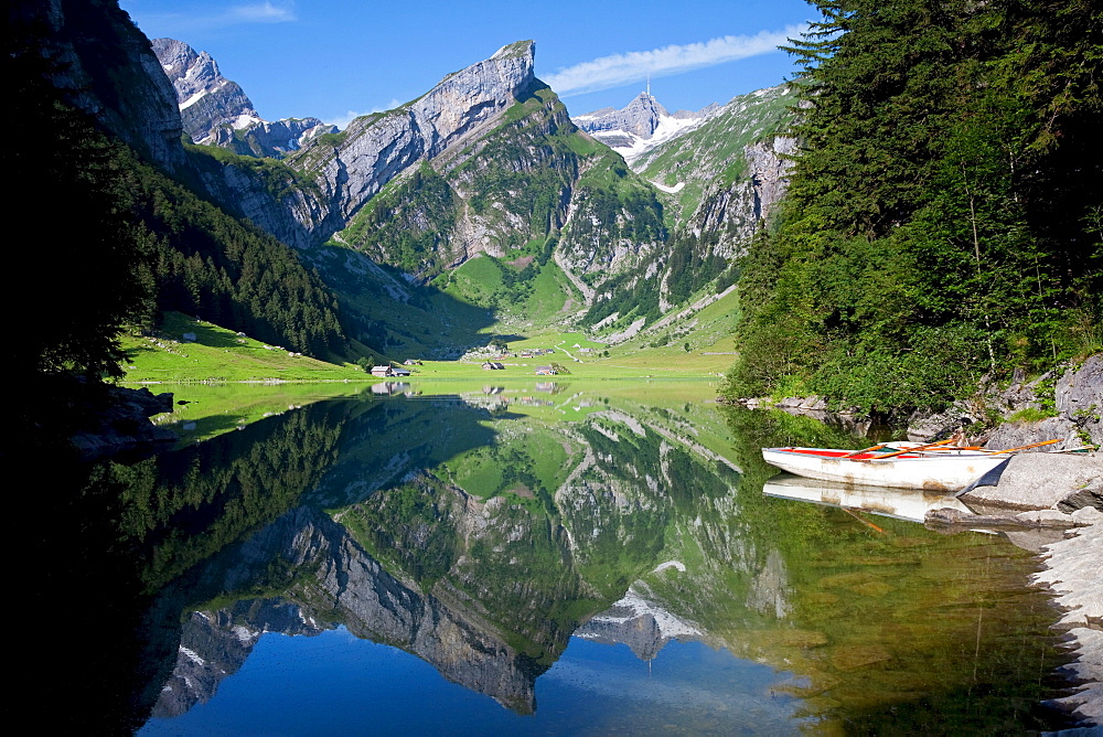 Calm morning view at Lake Seealpsee with reflections, view towards Saentis Mountain and two rowing boats in the foreground, Alpstein range, Appenzell region, Switzerland, Europe