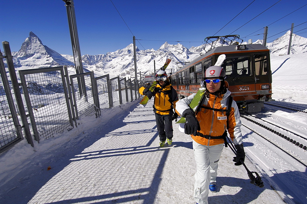 Skiers leaving the Gornergratbahn mountain rack railway in front of the Matterhorn Mountain, Zermatt, Valais or Wallis, Switzerland, Europe