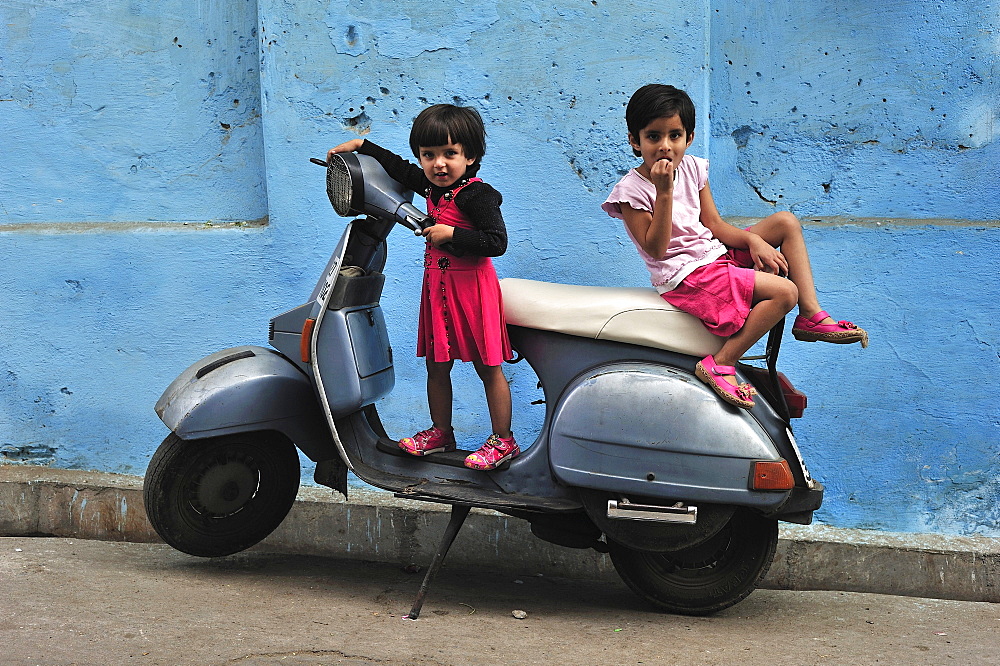 Young children playing on a motor scooter, Udaipur, Rajasthan, India, Asia