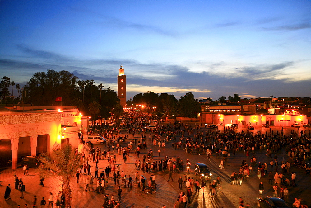 Koutoubia Mosque illuminated with red light, Djemaa el-Fna "Square of the Hanged Man" in the medina quarter of Marrakech at dusk with its countless food stalls, Marrakech, Morocco, Africa