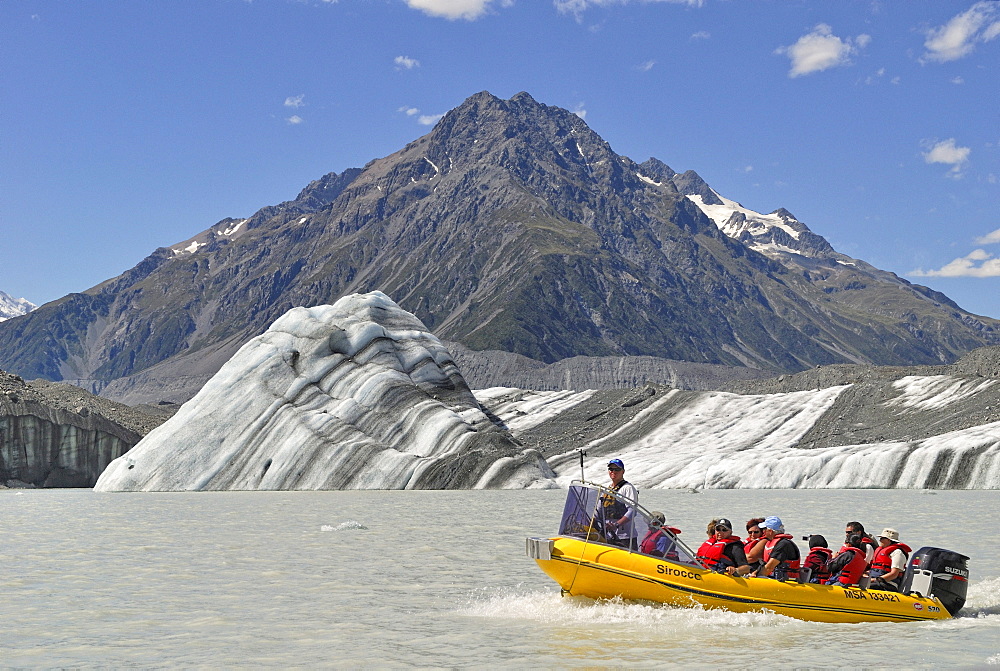 Icebergs and an excursion boat on Tasman Lake, in front of Mount Chutley, Mount Cook National Park, South Island, New Zealand