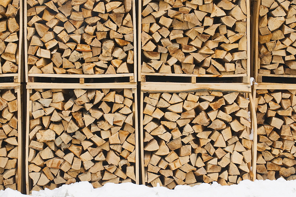 Accurately filled boxes of fire wood in the snow, timber, background