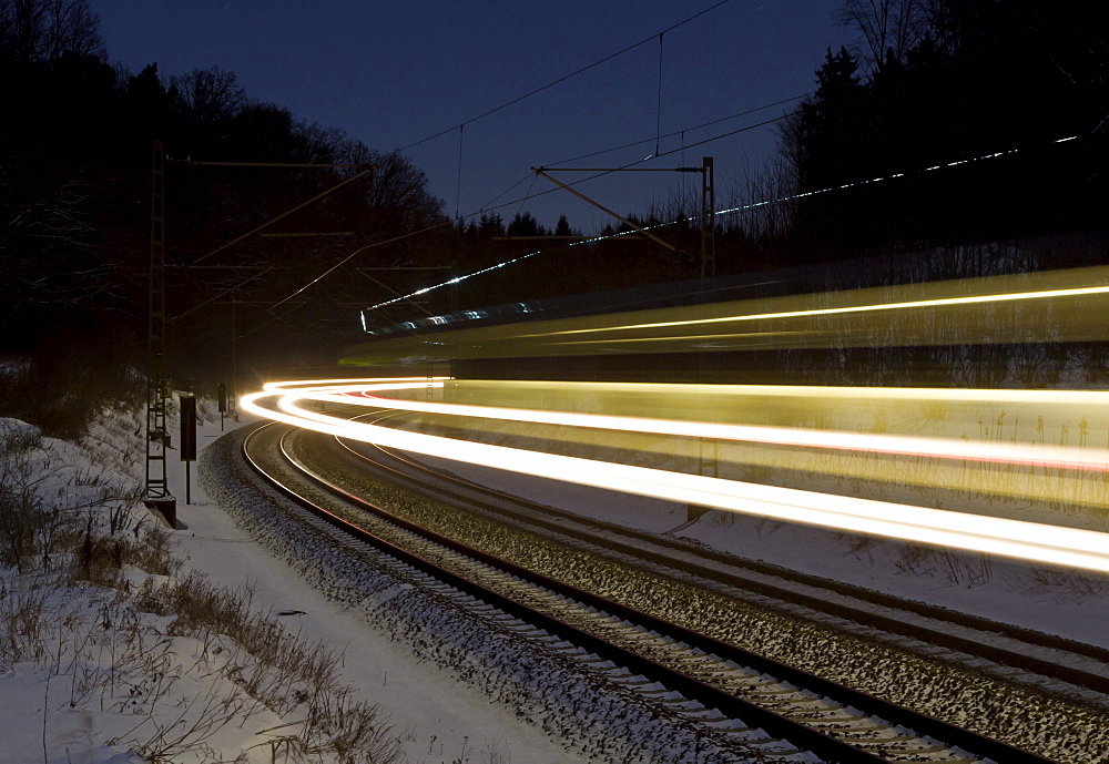 Light trace of a train in winter at night, Beimerstetten, Baden-Wuerttemberg, Germany, Europe