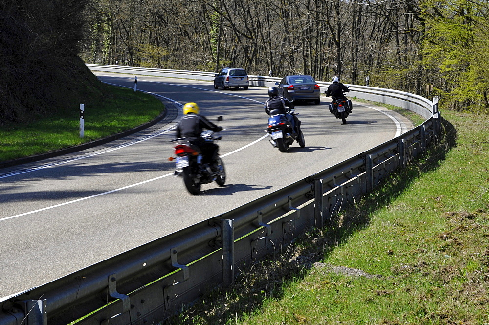 Motorcyclists in a curve on a country road with guard rail for protection, Eifel, Germany, Europe