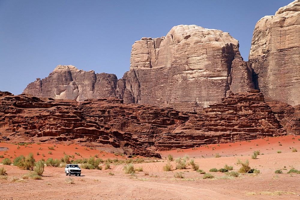 Off-road vehicle in front of mountains, vast plains and red sand in the desert, Wadi Rum, Hashemite Kingdom of Jordan, Middle East, Asia