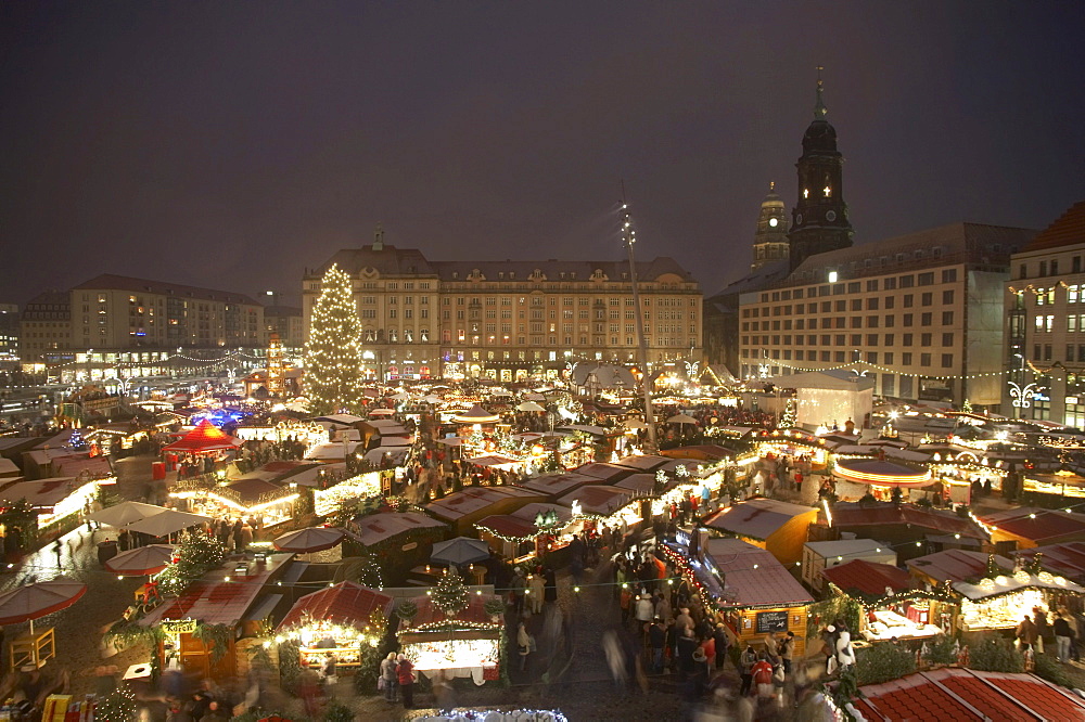 Christmas Market on Altmarkt Square with light snowfall, 575th Striezelmarkt 2009, overview with the Church of the Cross, a Christmas tree, a pyramid and a walk-through illuminated arch, Dresden, Saxony, Germany, Europe