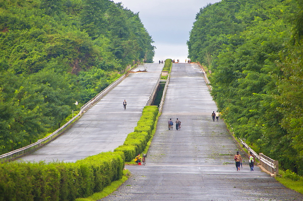 Cyclists on an empty highway, North Korea, Asia