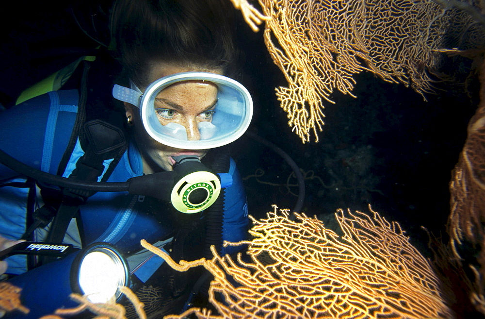 Diver's portraits behind a Gorgonie. The diver breaths a gas mixture, Nitrox.