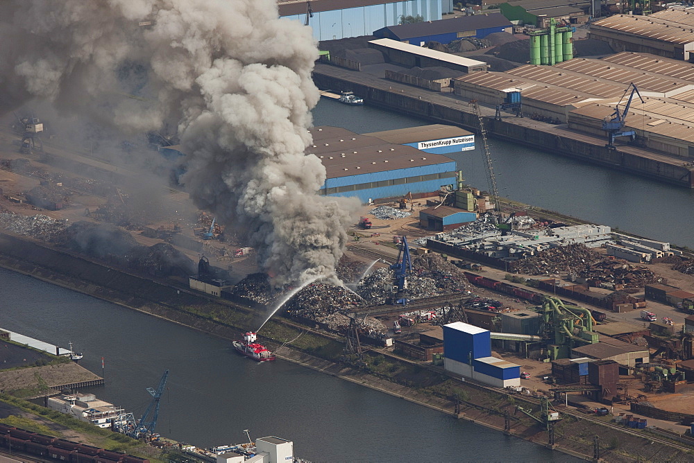 Aerial view, smoke, fire on a scrap island in the Duisport inland port, Duisburg, Ruhrgebiet region, North Rhine-Westphalia, Germany, Europe