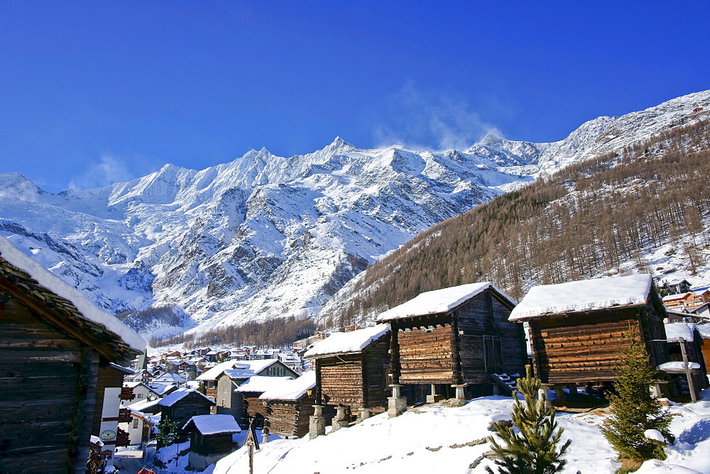 Wintry view of Saas Fee and three four-thousand-metre high mountain peaks, Taeschhorn mountain, 4491 m, Dom mountain, 4545 m, the highest mountain of Switzerland, and Lenzspitze mountain, 4264m, canton of Valais, Switzerland, Europe