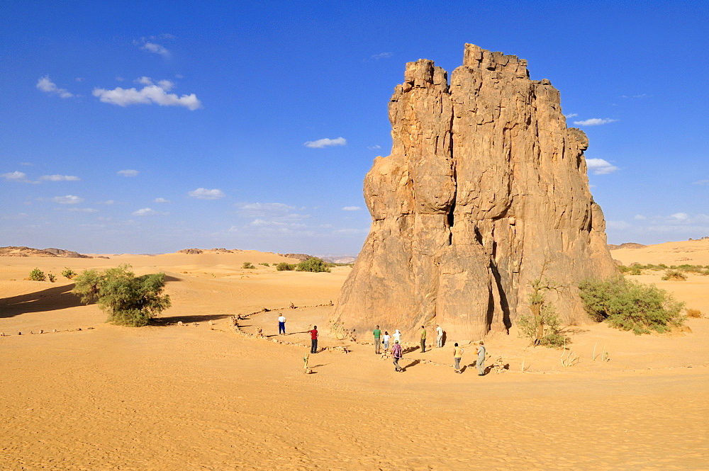 Tourists in front of the rock with the famous rock engraving of a crying cow, neolithic rock art near Djanet, Tassili n'Ajjer National Park, Unesco World Heritage Site, Wilaya Illizi, Algeria, Sahara, North Africa