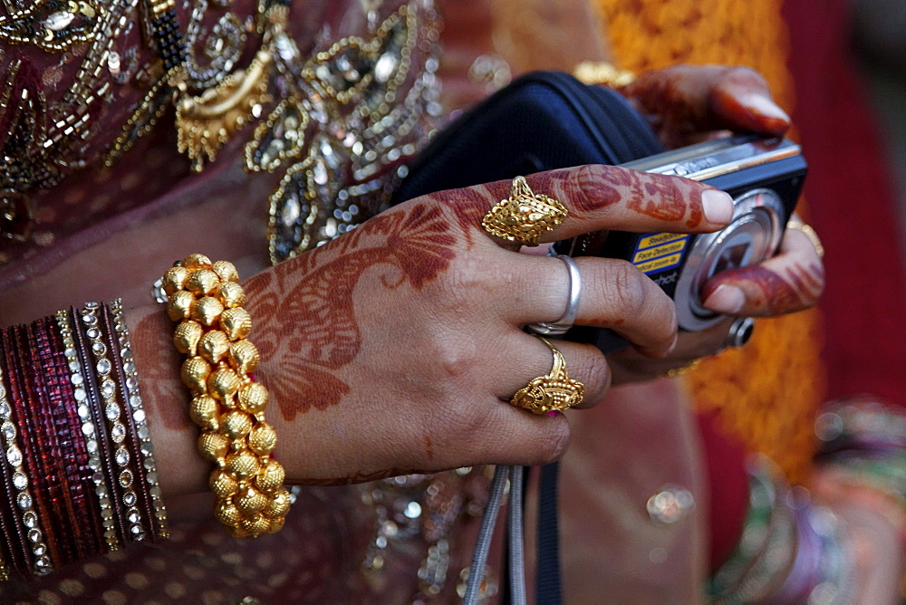 Indian woman's decorated hand holding a digital camera, Golu Devta Temple or Golu Devata Temple, Temple of the Bells, a temple for the God Golu, Ghorakhal, Uttarakhand, North India, India, Asia