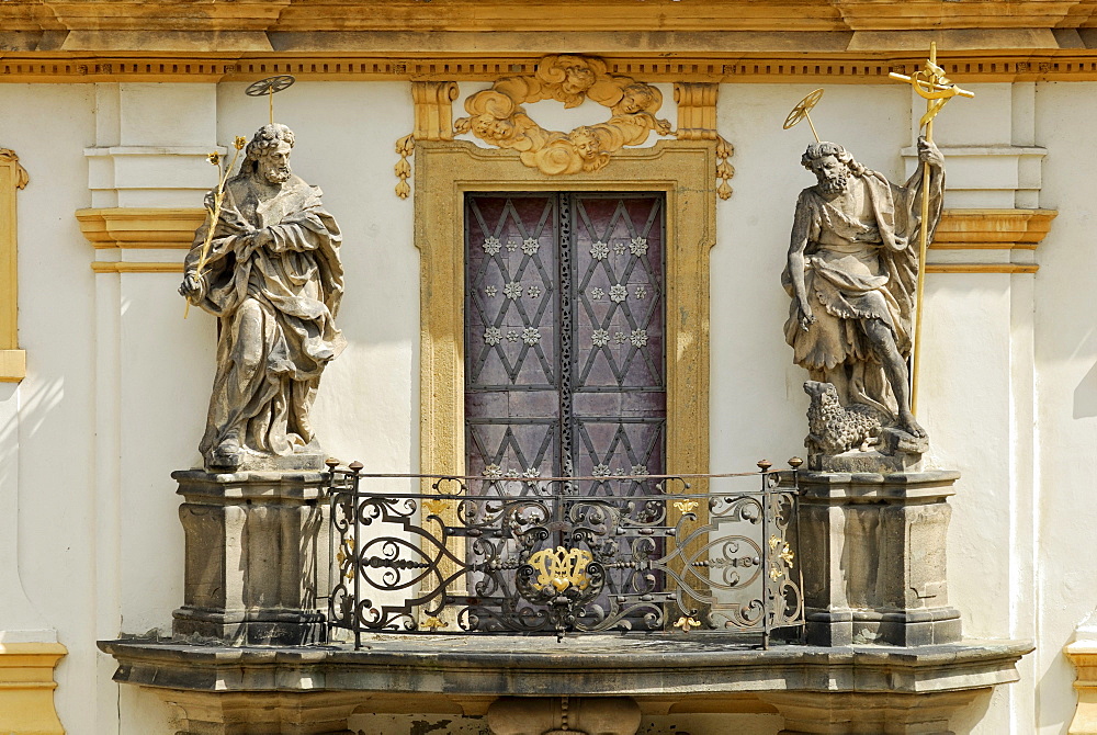 Balcony with statues of saints above the portal of Loreta Church, St. Joseph with lilies and Saint John the Baptist holding a cross and a lamb, Prague, Czech Republic, Europe