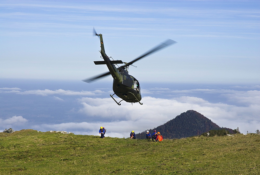 Helicopter being marshalled by rescue workers, German army helicopter in approach for landing, Chiemgau Alps, Bavaria, Germany, Europe