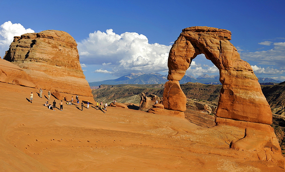 Tourists taking pictures in front of Delicate Arch, rock arch, La Sal Mountains, Arches National Park, Moab, Utah, Southwestern United States, United States of America, USA