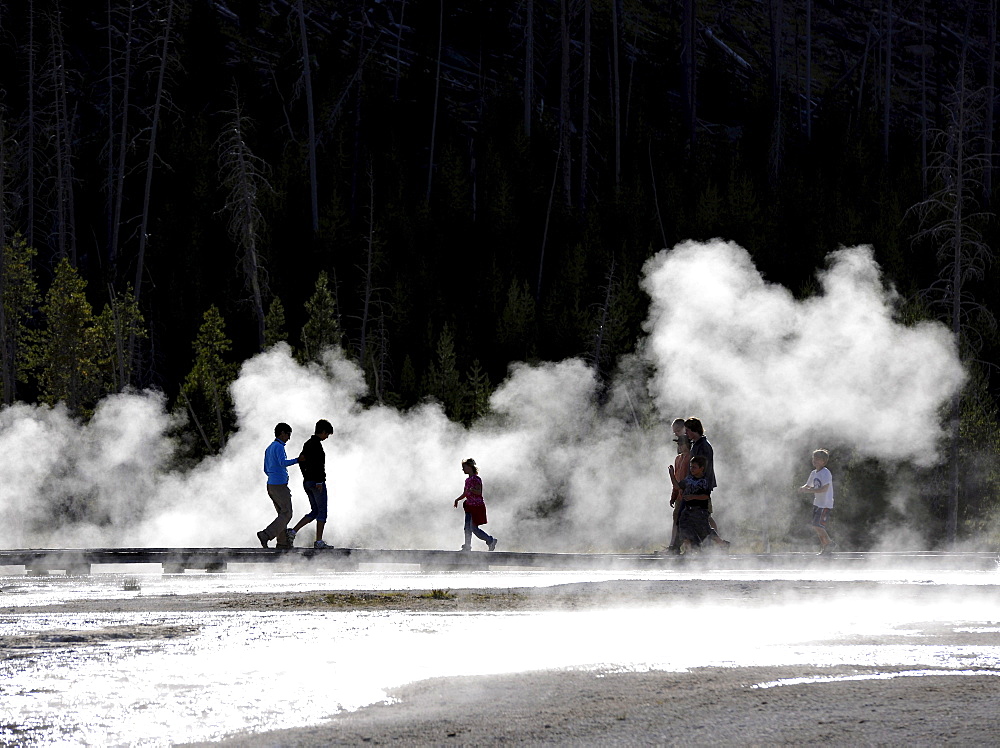 Tourists on a boardwalk amidst the steam of the springs and geysers, Black Sand Basin, Upper Geyser Basin, Yellowstone National Park, Wyoming, United States of America, USA