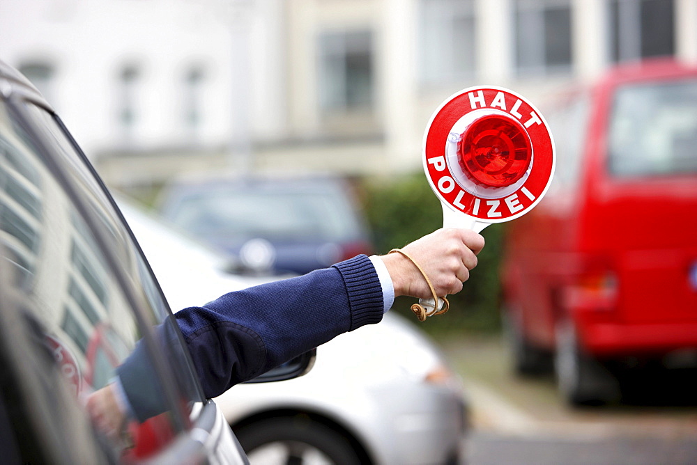 Unmarked police car, police officer stopping a vehicle with a signalling disc