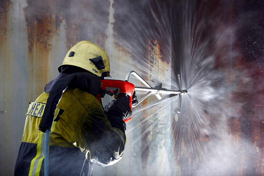 High-pressure extinguishing system, Cobra, the Fire Service Training Centre, Heat, a firefighter demonstrating the possibility of using a high pressure of 300 bar to cut through materials such as concrete or steel to then extinguish a blaze in an inaccess