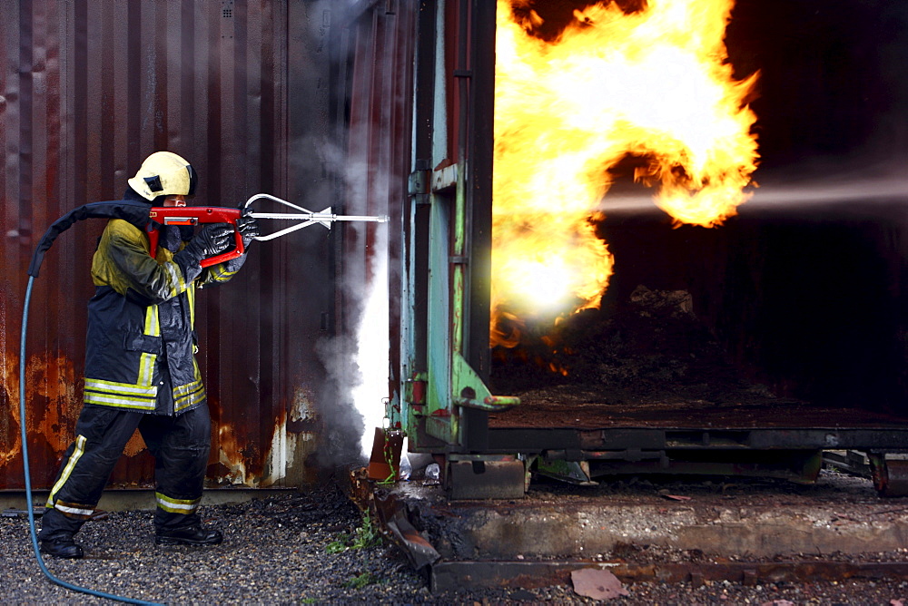 High-pressure extinguishing system, Cobra, the Fire Service Training Centre, Heat, a firefighter demonstrating the possibility of using a high pressure of 300 bar to cut through materials such as concrete or steel to then extinguish a blaze in an inaccess