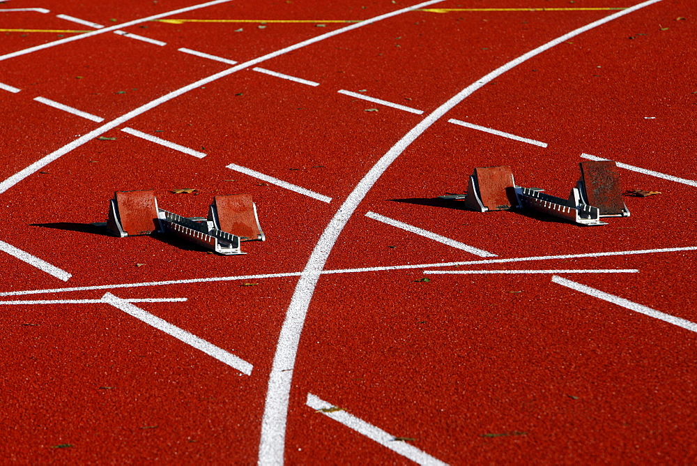 Tartan track of a sports field, starting blocks for sprinting disciplines, lane markings