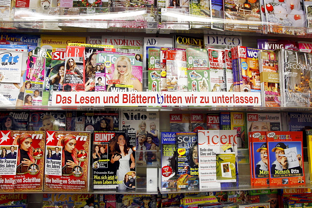 Shelves with magazines in a shop, lettering "Das Lesen und Blaettern bitten wir zu unterlassen", German for "Please refrain from reading or skimming through the magazines"