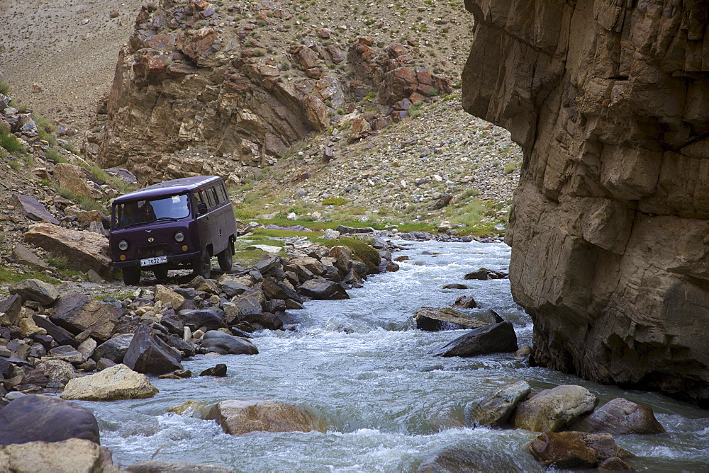 UAZ off-road vehicle bus at a creek in the Pamir mountain range, Tajikistan, Central Asia