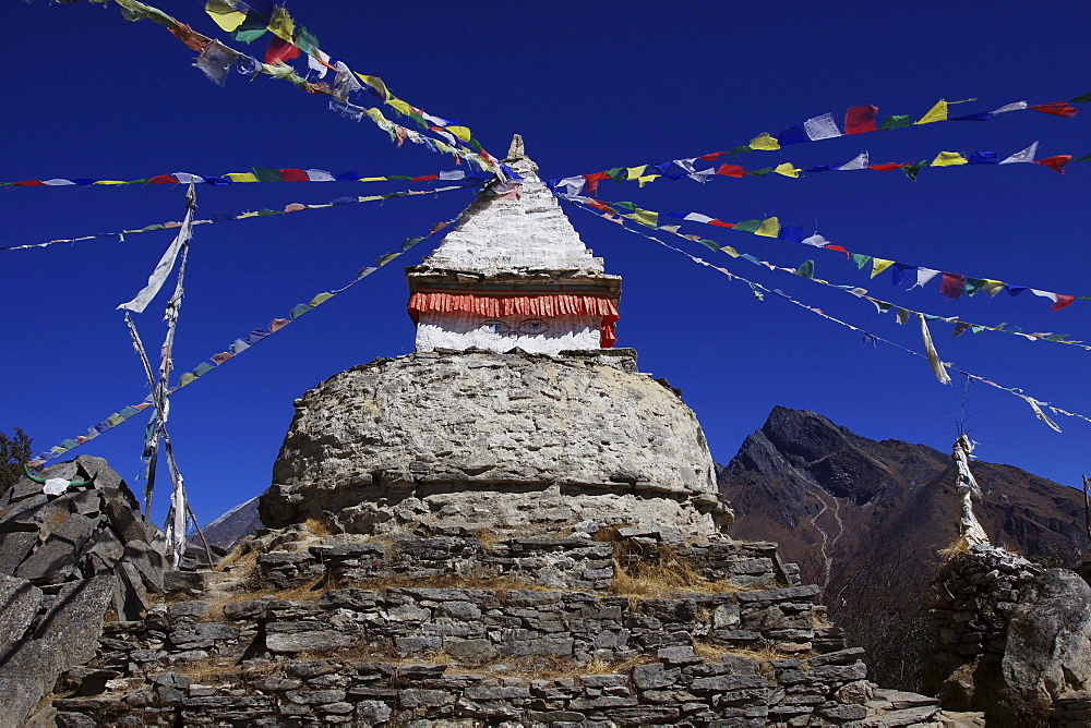 A stupa with prayer flags and Mani stones in Mongla, Khumbu, Sagarmatha National Park, Nepal, Asia