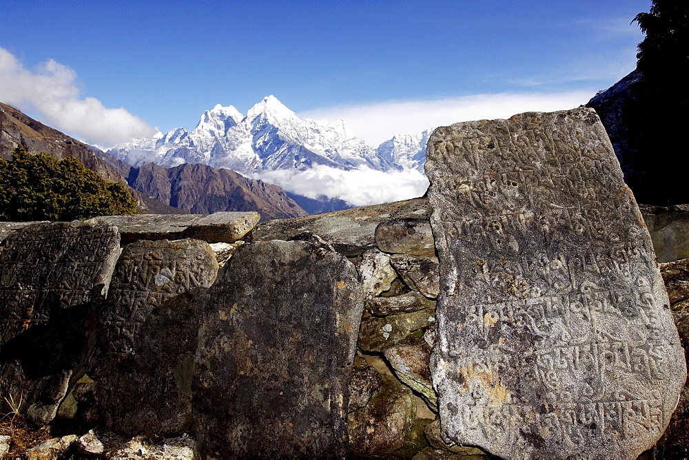 Piled up Mani stones, stone tablets with religious writings at the Buddhist monastery of Thame, behind Mt. Kangtega and Mt. Thamserku, Khumbu, Sagarmatha National Park, Nepal, Asia