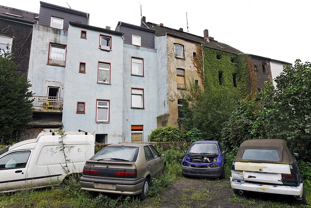 Car wrecks in a backyard, Bruckhausen district, Duisburg, North Rhine-Westphalia, Germany, Europe