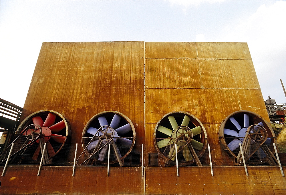 Industrial building with four brightly painted ventilation propellers, former Thyssen blast furnace plant, today Duisburg-Nord Landscape Park, North Rhine-Westphalia, Germany, Europe