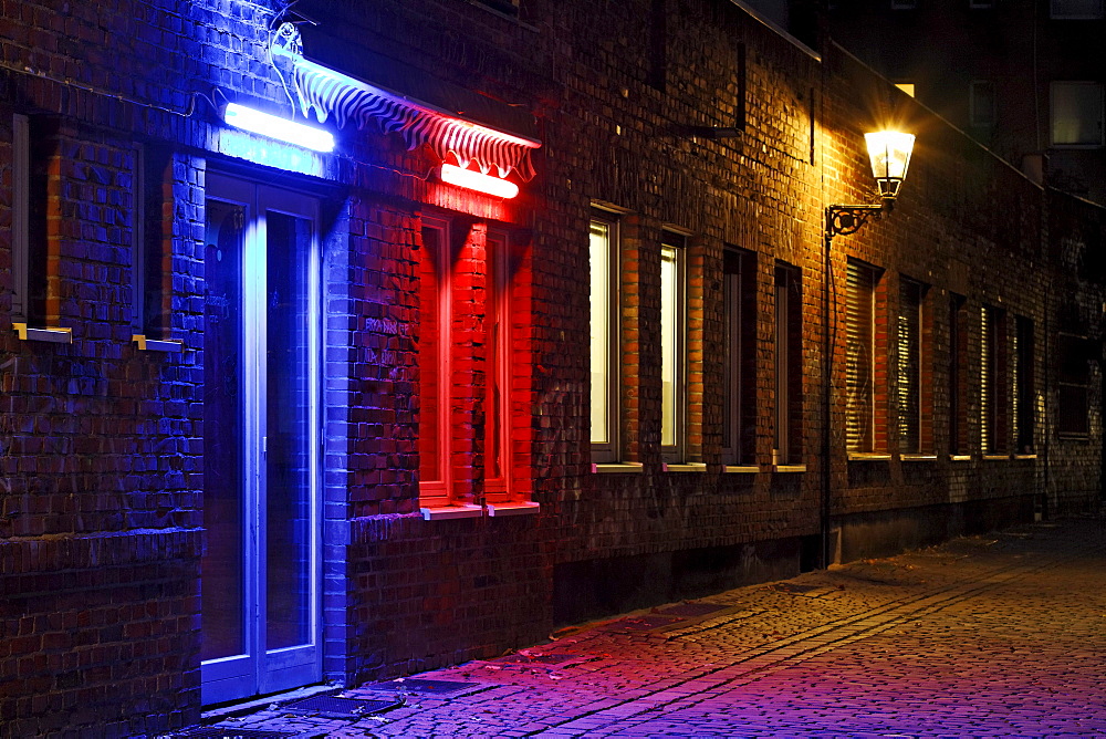 Alley in the historic district, nice ambiance, blue illuminated door, red illuminated window, Duesseldorf, North Rhine-Westphalia, Germany, Europe