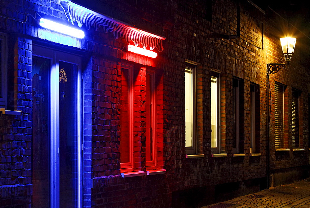 Alley in the historic district, nice ambiance, blue illuminated door, red illuminated window, Duesseldorf, North Rhine-Westphalia, Germany, Europe