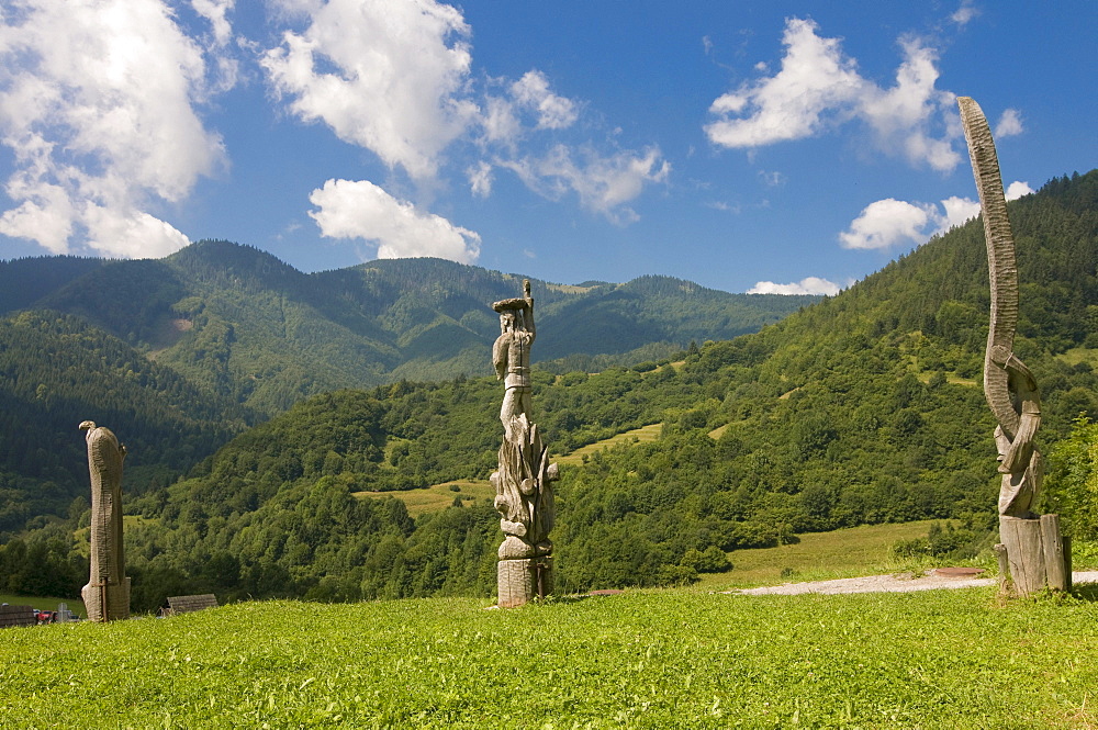 Meadow with wooden statues in the High Tatras mountain range near Vlkolinec, Slowakia, Europe