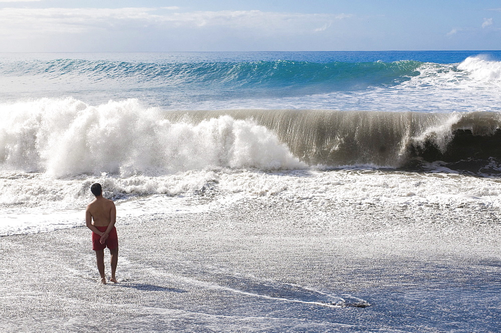 Man standing in front of a giant wave, La Palma, Canary Islands, Spain, Europe