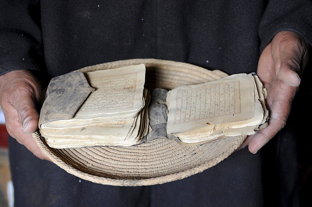 Hands holding old manuscripts of the holy Koran, Ouadane, Mauritania, northwestern Africa