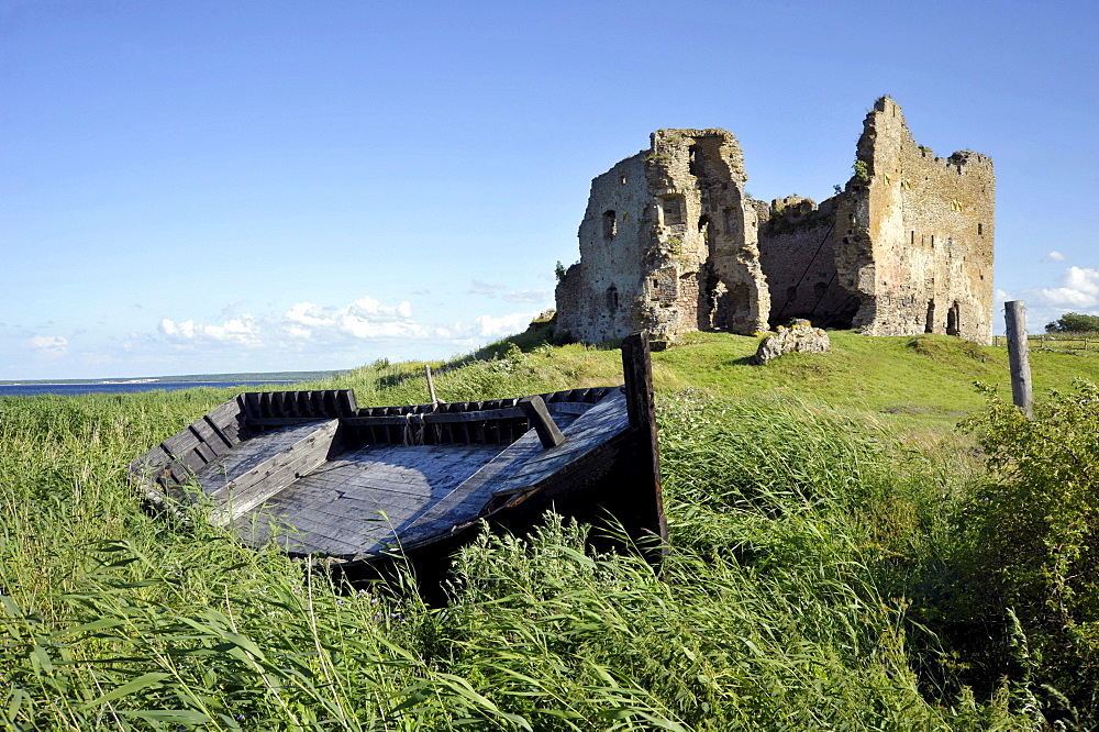 Boat on a Baltic Sea beach in front of the ruins of the Castle of the Order of the Teutonic Knights, Toolse, Estonia, Baltic States, Northern Europe