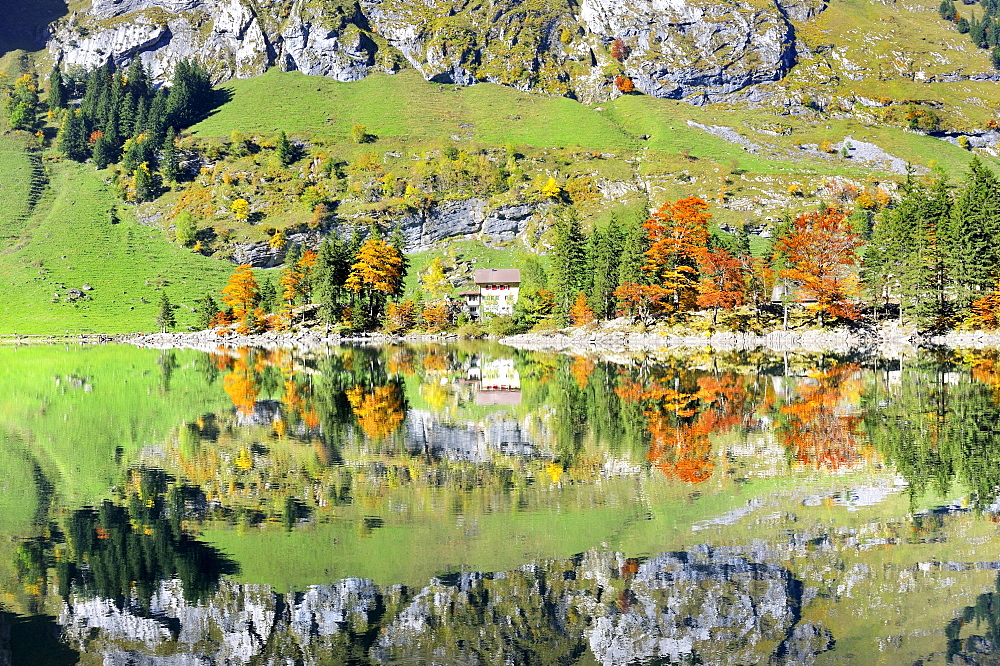 Ebenalp Mountain guest house on a penisula, reflected in Seealp Lake, at 1143 m altitude, Canton of Appenzell Inner-Rhodes, Switzerland, Europe