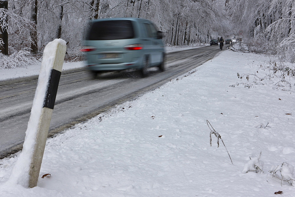 Snow-covered road in winter with traffic, Hesse, Germany, Europe