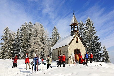 Hikers at St. Anne's Chapel on Germany's first premium winter hiking track, Hemmersuppenalm, Reit im Winkl, Bavaria, Germany, Europe