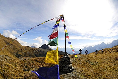 Mountain bikers in front of prayer flags, on the Carnian trail, Mt. Helm, Alta Pusteria, South Tyrol, Dolomites, Italy, Europe