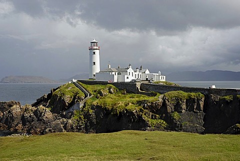 Fanad Head Lighthouse on rocky cliff, rain shower, County Donegal, Ireland, Europe