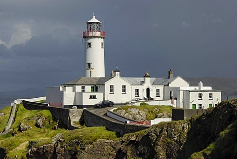 Fanad Head Lighthouse on rocky cliff, rain shower, County Donegal, Ireland, Europe