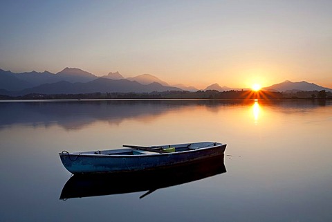 Evening mood at Lake Hopfensee with a boat near Fuessen in Allgaeu, Bavaria, Germany, Europe