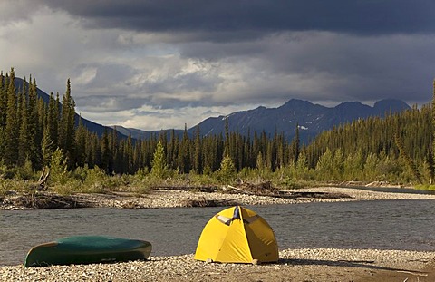 Camp on gravel bar, tent and canoe, Pelly Mountains behind, upper Liard River, Yukon Territory, Canada