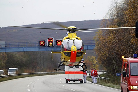 An ADAC EC 135 rescue helicopter taking-off at an accident site on the A61 motorway near Niederzissen, Rhineland-Palatinate, Germany, Europe