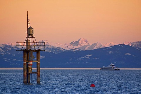 Lighthouse in Lake Constance with view to the mountain chain of the Alps in evening sky, Konstanz, Baden-Wuerttemberg, Germany, Europe