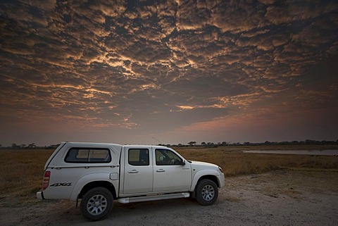 Four-wheel-drive vehicle at sunrise, Hwange National Park, Zimbabwe, Africa