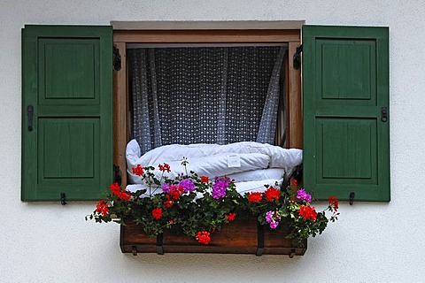 Duvets hanging out of a window with flower box for airing, Mittenwald, Upper Bavaria, Bavaria, Germany, Europe