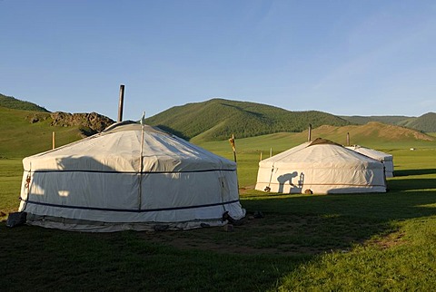 Yurt camp or ger camp in the grasslands at the Orkhon Waterfall in front of the mountains of the Khuisiin Naiman Nuur Nature Reserve, Orkhon Khuerkhree, Kharkhorin, Oevoerkhangai Aimak, Mongolia, Asia